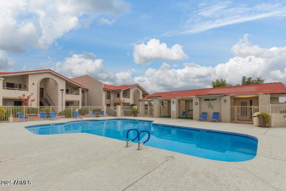 10610 South 48th Street, Unit 1064 Phoenix, AZ 85044 - Photo 6 of 14 a view of a white building with a swimming pool and sitting area