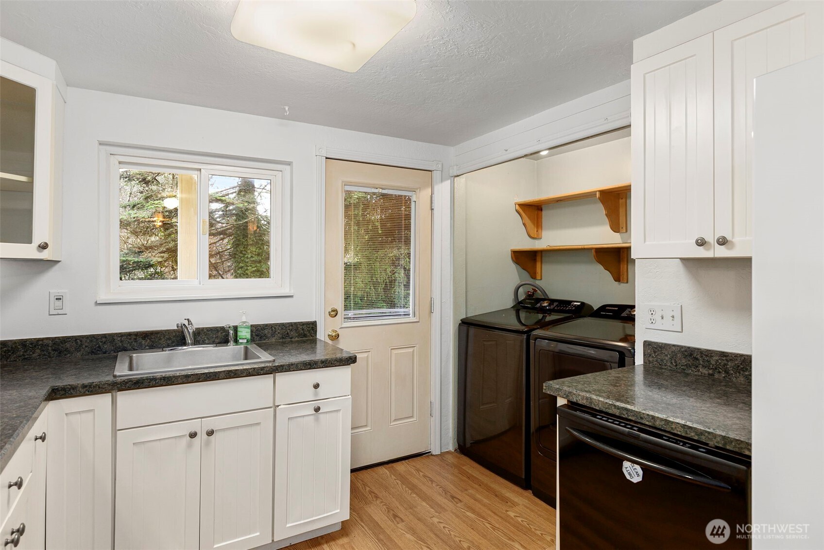 26009 Barrett Road Northeast Kingston, WA 98346 - Photo 8 of 25 a kitchen with a sink stove top oven and cabinets