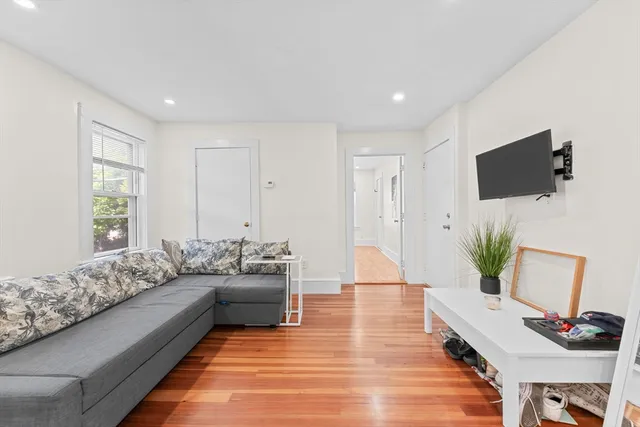 a living room with furniture a flat screen tv and a potted plant