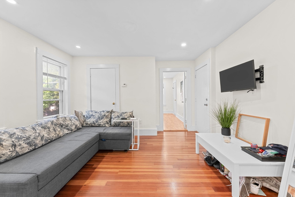 14 Glendale Street, Unit 14 Maynard, MA 01754 - Photo 4 of 29 a living room with furniture a flat screen tv and a potted plant