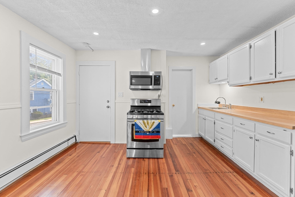 14 Glendale Street, Unit 14 Maynard, MA 01754 - Photo 5 of 29 a kitchen with sink cabinets and wooden floor
