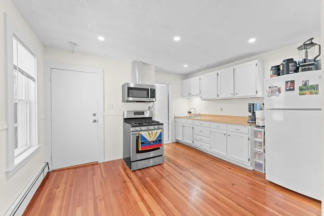 a kitchen with stainless steel appliances a refrigerator and a stove top oven