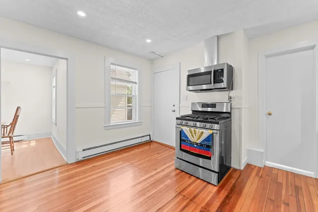 a living room with stainless steel appliances kitchen island granite countertop a refrigerator stove and sink