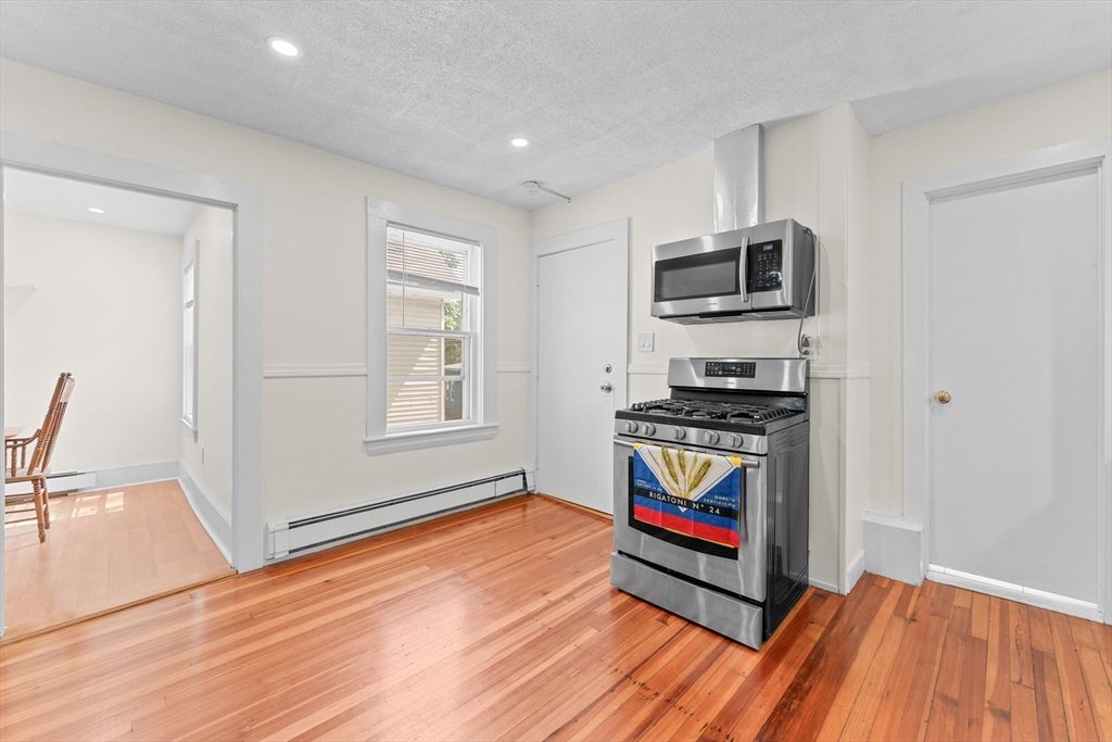 14 Glendale Street, Unit 14 Maynard, MA 01754 - Photo 7 of 29 a living room with stainless steel appliances kitchen island granite countertop a refrigerator stove and sink