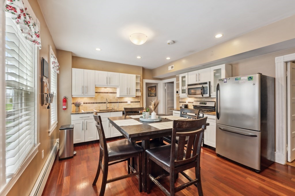 73 Cranch Street, Unit 73 Quincy, MA 02169 - Photo 13 of 22 a kitchen with a table chairs refrigerator and microwave