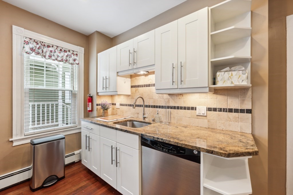 73 Cranch Street, Unit 73 Quincy, MA 02169 - Photo 15 of 22 a kitchen with stainless steel appliances granite countertop a sink and dishwasher with wooden cabinets