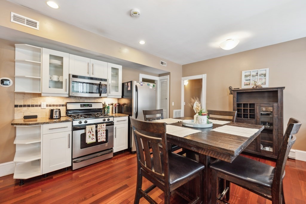 73 Cranch Street, Unit 73 Quincy, MA 02169 - Photo 16 of 22 a kitchen with a stove a refrigerator and a dining table