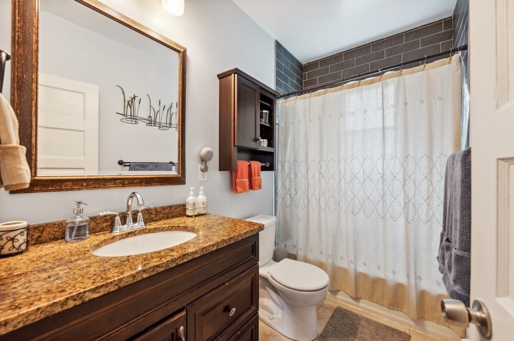 73 Cranch Street, Unit 73 Quincy, MA 02169 - Photo 6 of 22 a bathroom with a granite countertop sink and a mirror