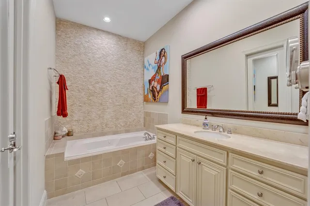 a bathroom with a tub a sink and a mirror