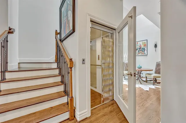 a view of a hallway with wooden floor and staircase