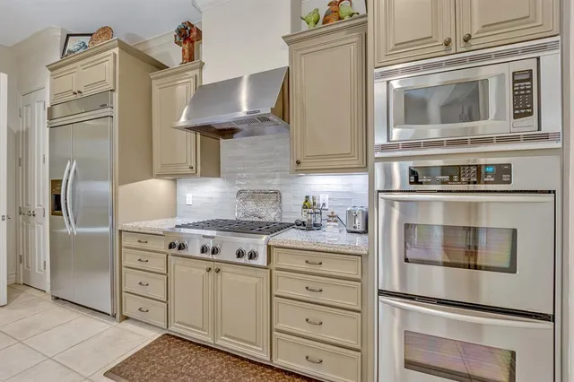a kitchen with cabinets stainless steel appliances and wooden floor