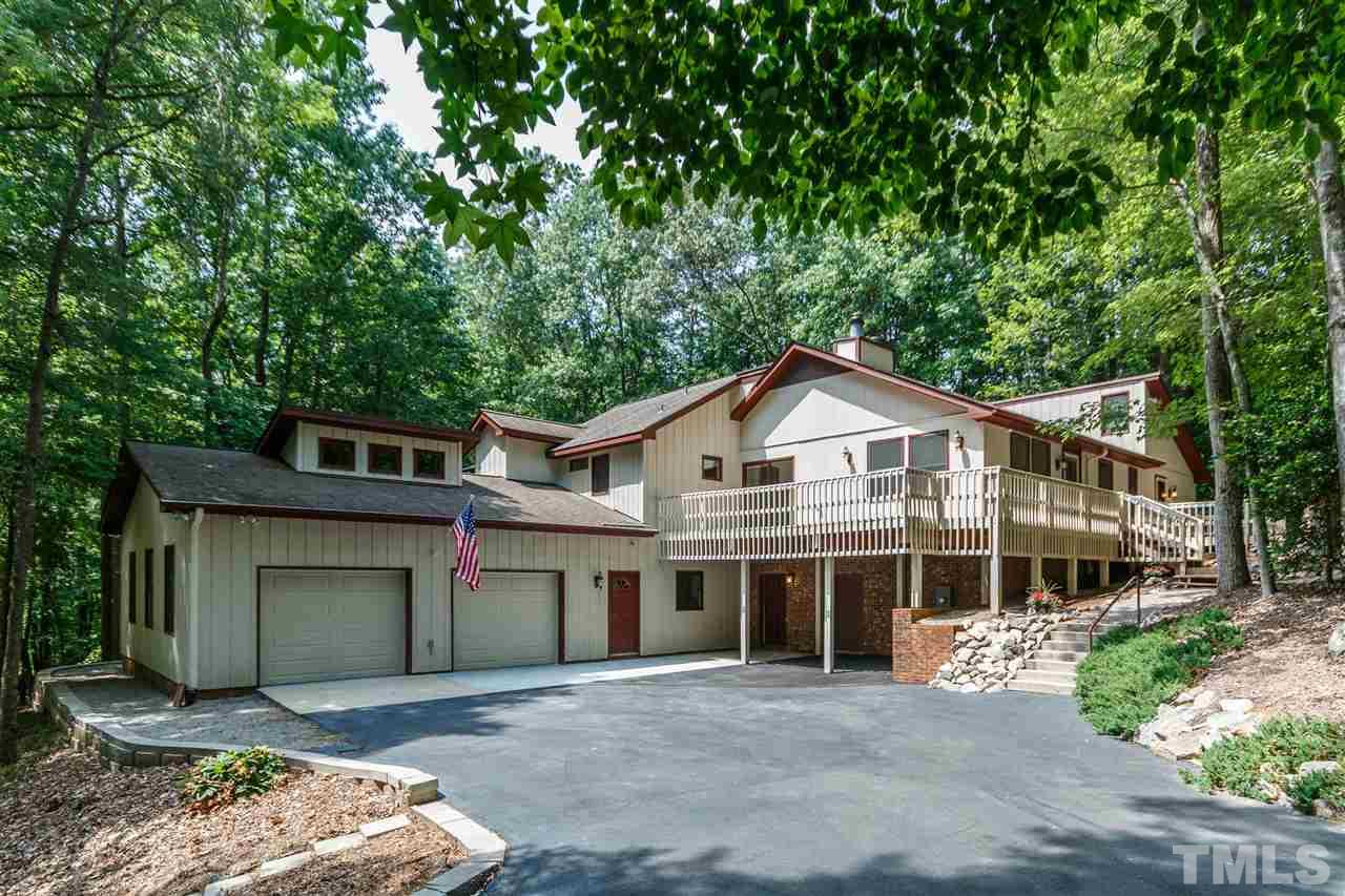 a front view of a house with a garden and trees