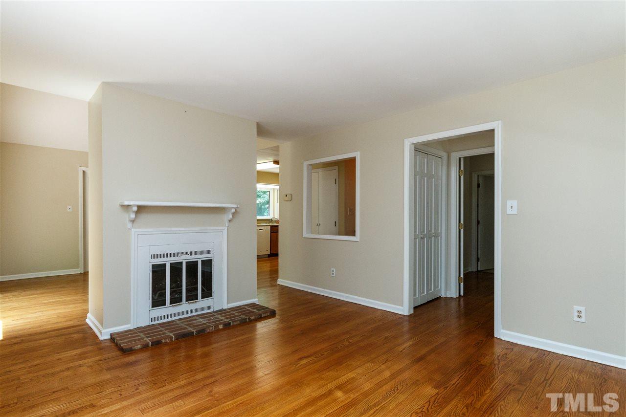 11604 Black Horse Run Raleigh, NC 27613 - Photo 2 of 29 a view of a livingroom with wooden floor and a fireplace