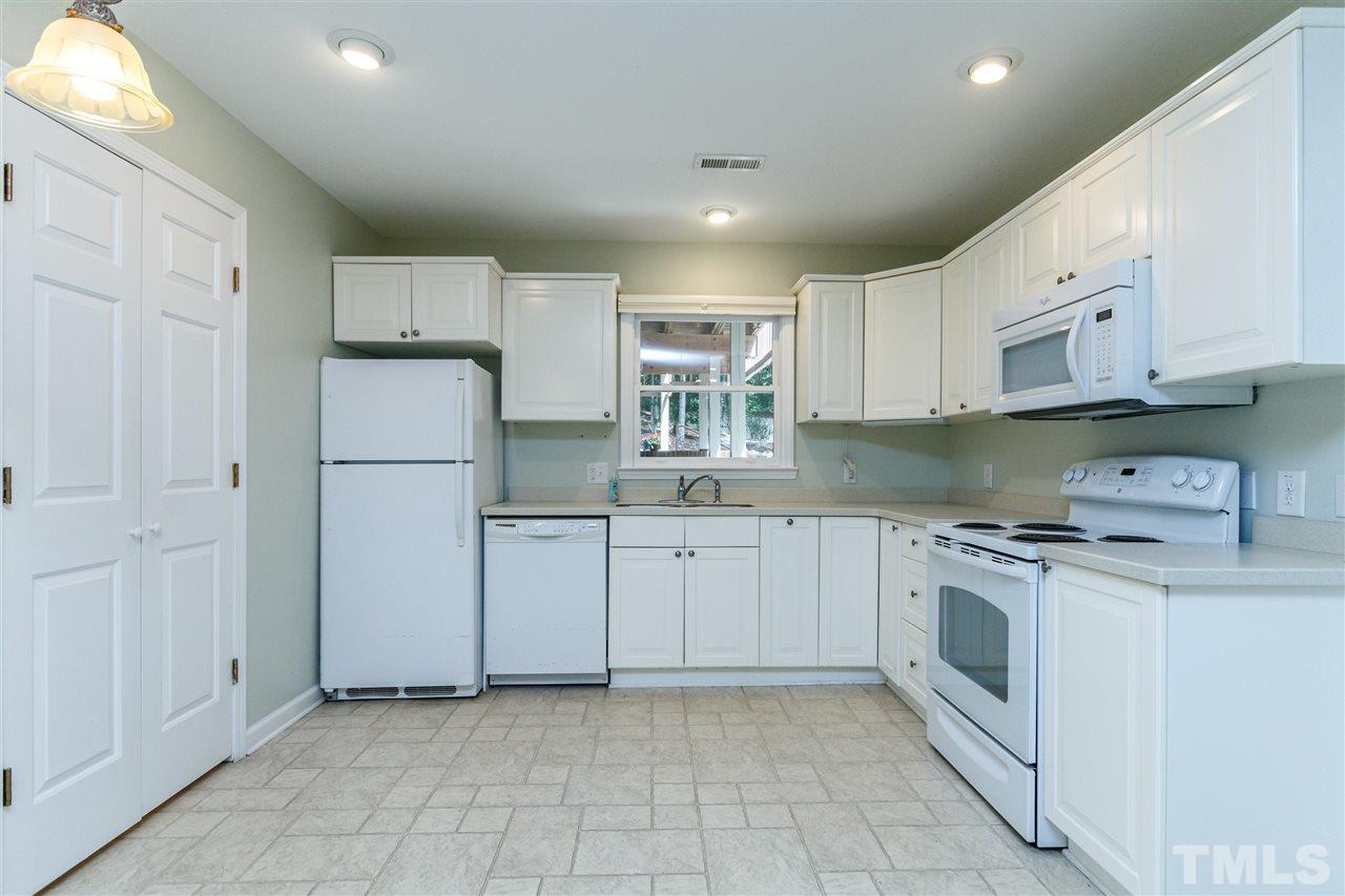 11604 Black Horse Run Raleigh, NC 27613 - Photo 21 of 29 a kitchen with white cabinets and white appliances