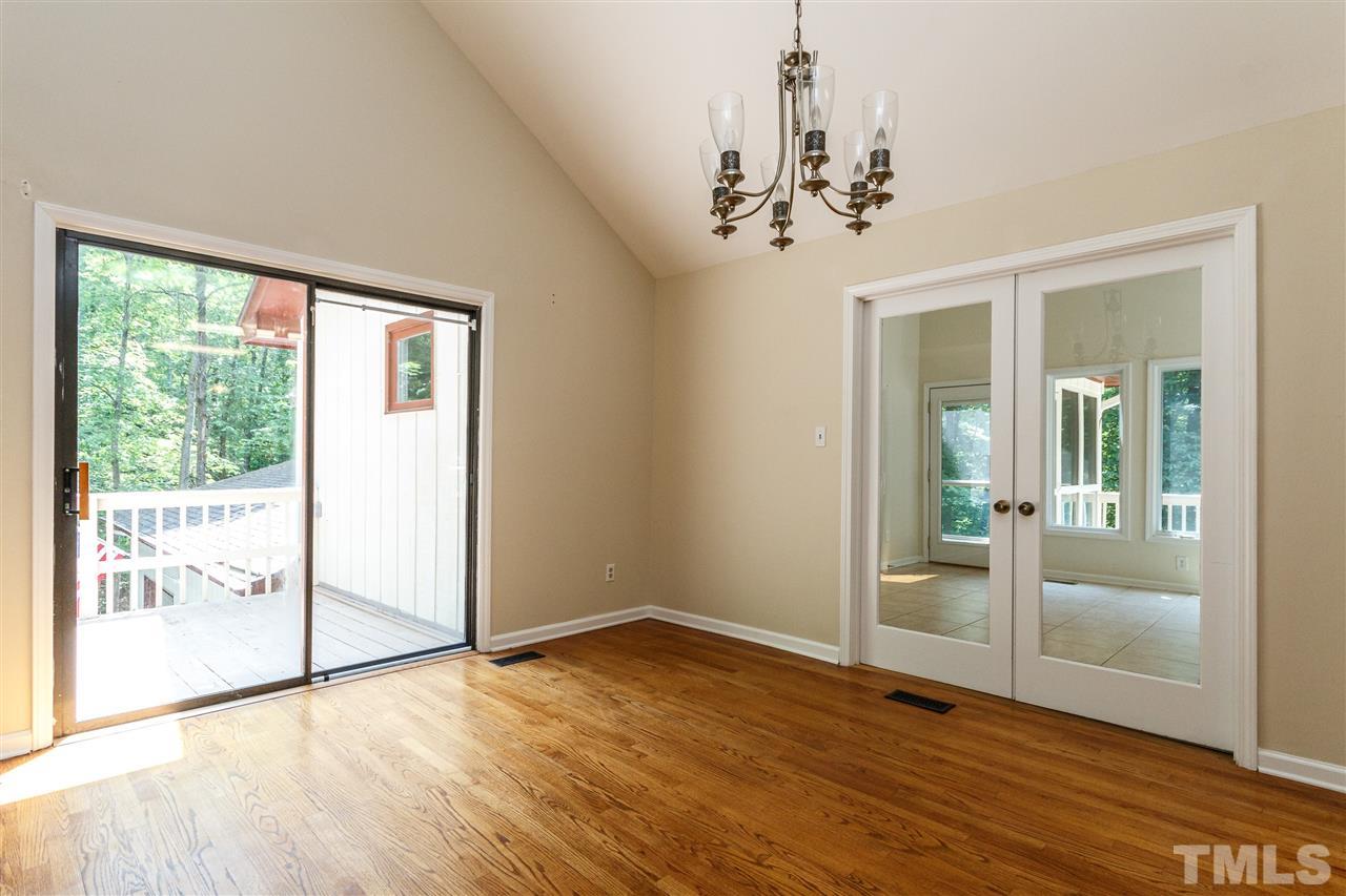 11604 Black Horse Run Raleigh, NC 27613 - Photo 4 of 29 en empty room with wooden floor chandelier and windows