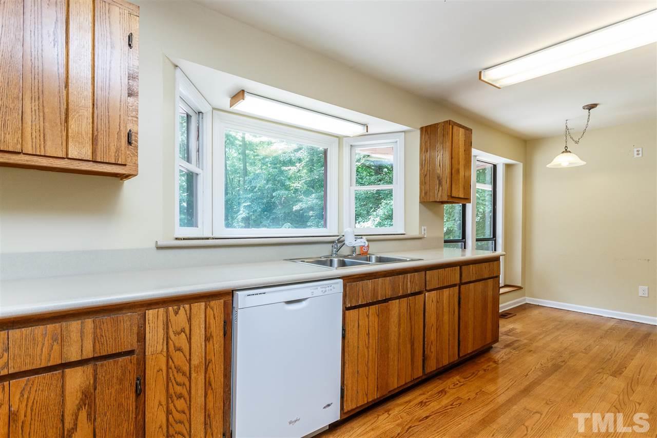 11604 Black Horse Run Raleigh, NC 27613 - Photo 7 of 29 a kitchen with stainless steel appliances granite countertop wooden cabinets a sink and a large window