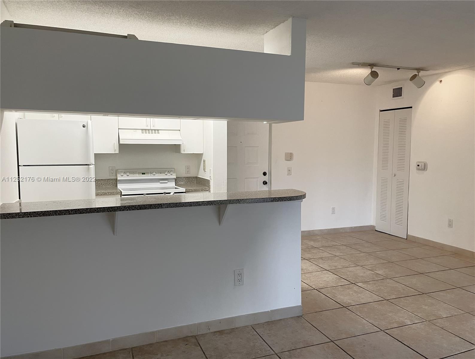 420 South Park Road, Unit 2105 Hollywood, FL 33021 - Photo 3 of 11 a kitchen with kitchen island a sink a stove and a refrigerator
