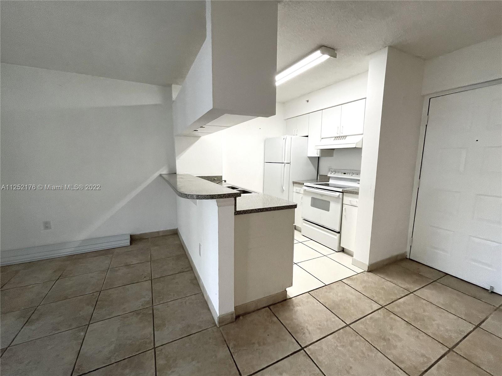 420 South Park Road, Unit 2105 Hollywood, FL 33021 - Photo 4 of 11 a kitchen with a stove a sink and a refrigerator