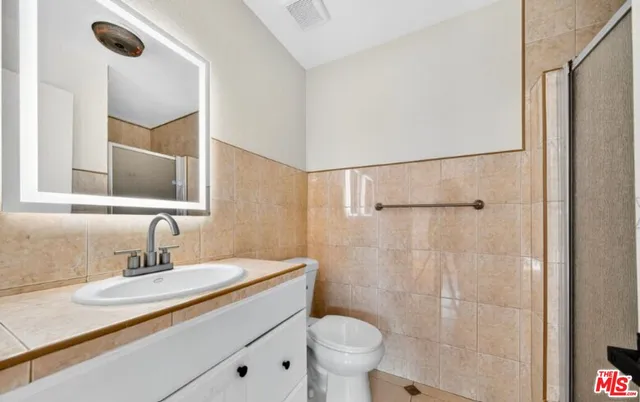 a bathroom with a sink toilet a mirror and shower