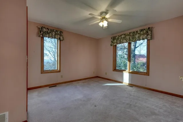 an empty room with a ceiling fan and a window