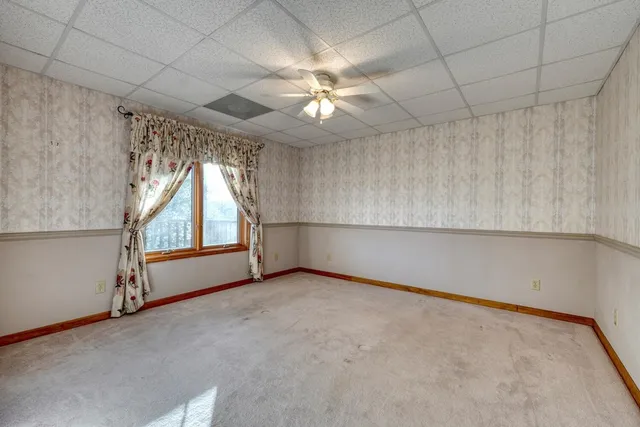 a view of an empty room with a chandelier fan