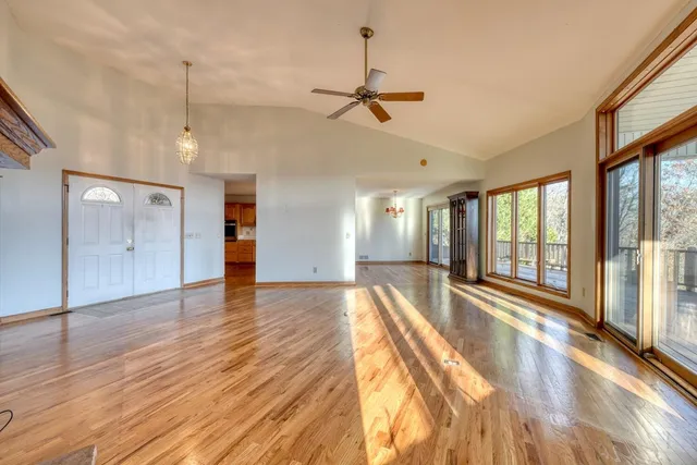 a view of an empty room with window and wooden floor