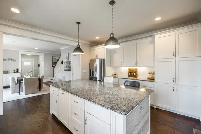 a kitchen with granite countertop a stove a sink a counter space and stainless steel appliances