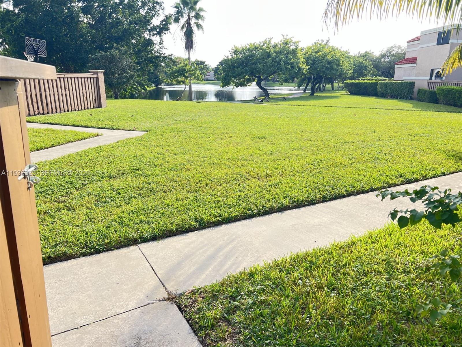 8116 Severn Drive, Unit C Boca Raton, FL 33433 - Photo 18 of 19 a view of a garden with a bench in the garden