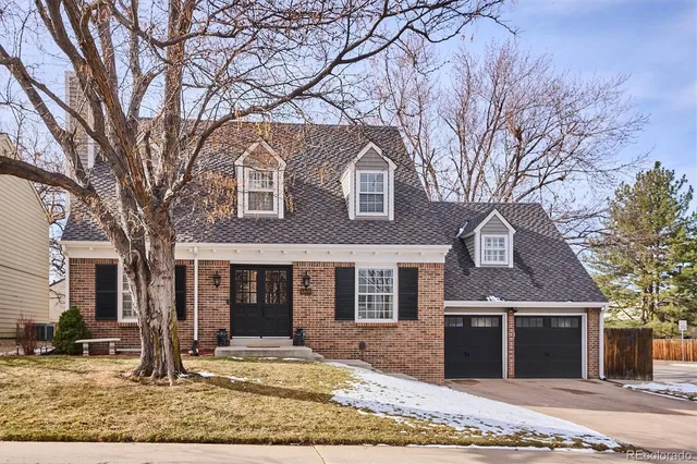 a front view of a house with garden and trees