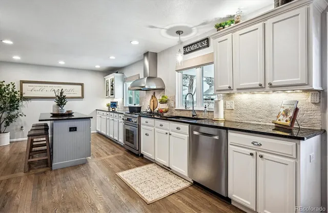 a kitchen with granite countertop white cabinets and white appliances