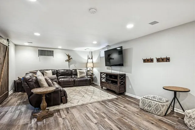 a view of an empty room with staircase and kitchen view