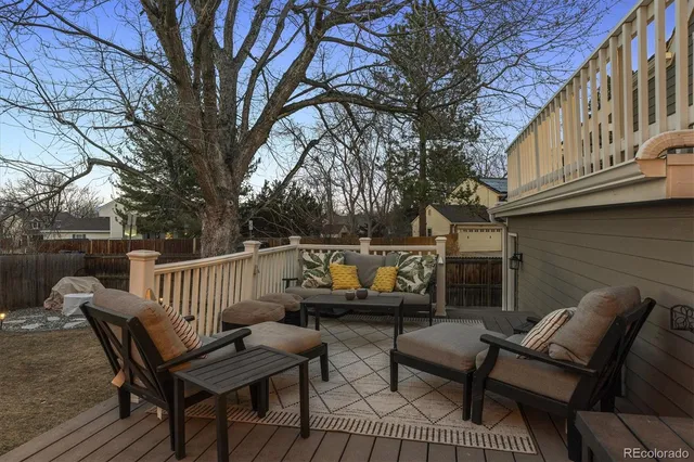a patio with table and chairs and potted plants