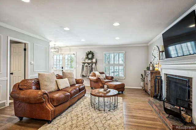 a living room with furniture a flat screen tv and a fireplace
