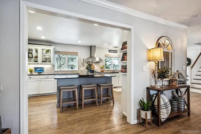 a kitchen with stainless steel appliances a dining table chairs and wooden floor