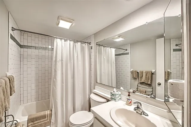 a bathroom with a sink vanity mirror and toilet