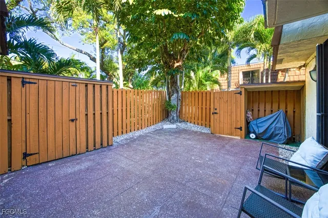 a view of backyard with wooden fence and trees