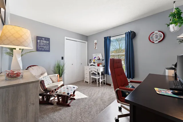 a view of a workspace with furniture and a window