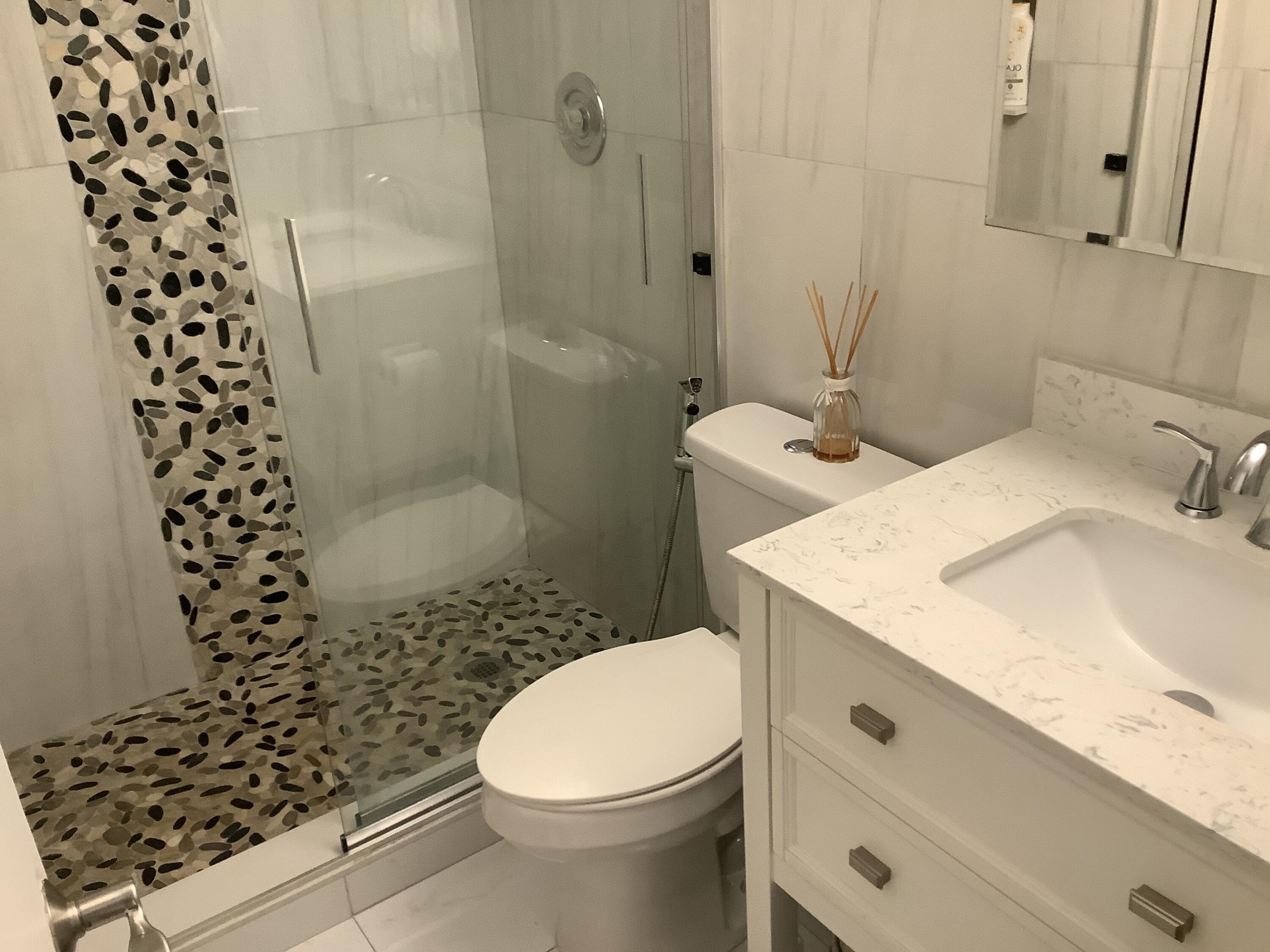 22040 Palms Way, Unit 204 Boca Raton, FL 33433 - Photo 16 of 20 a bathroom with a sink toilet and shower