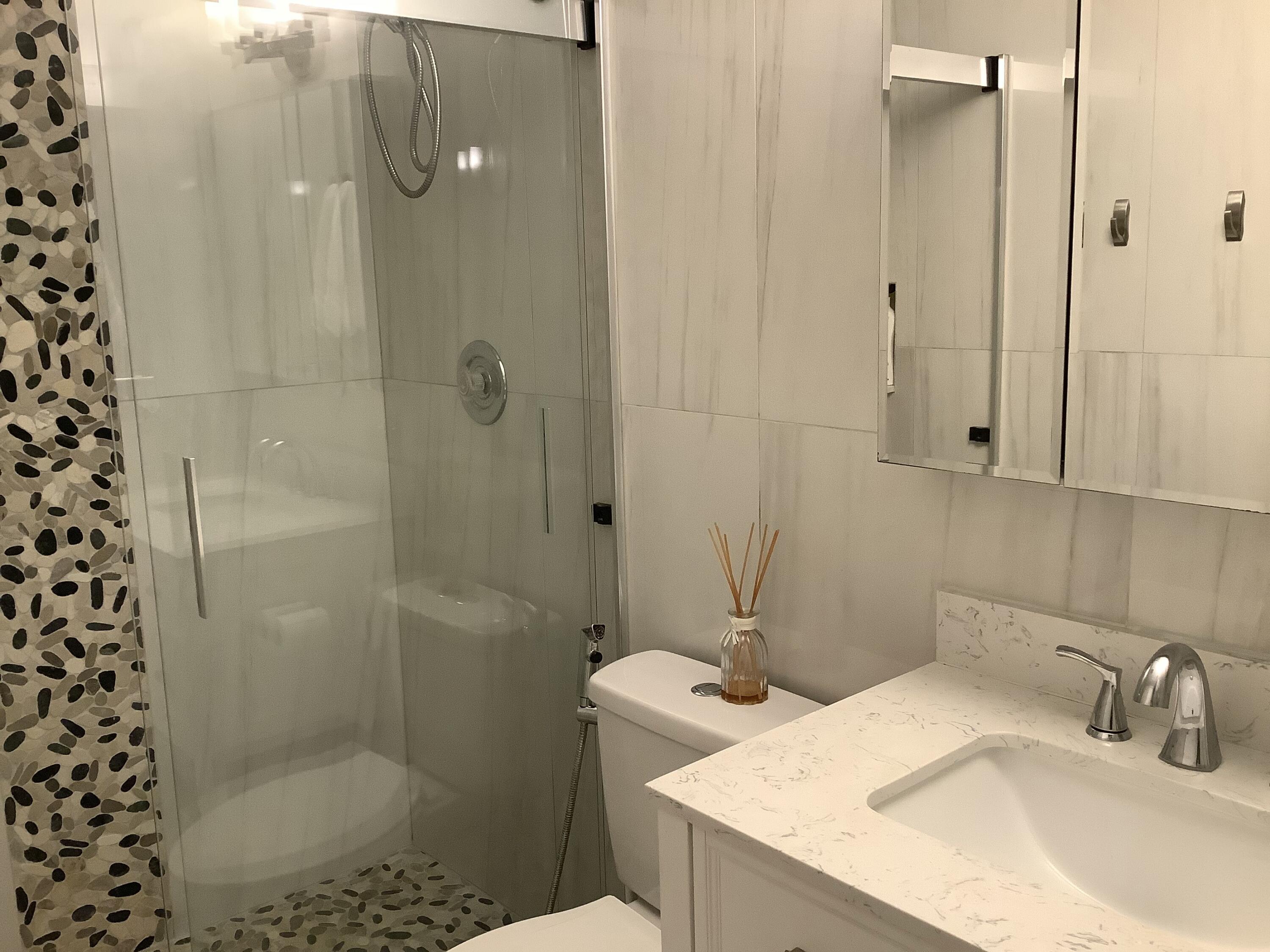 22040 Palms Way, Unit 204 Boca Raton, FL 33433 - Photo 17 of 20 a bathroom with a sink toilet and shower