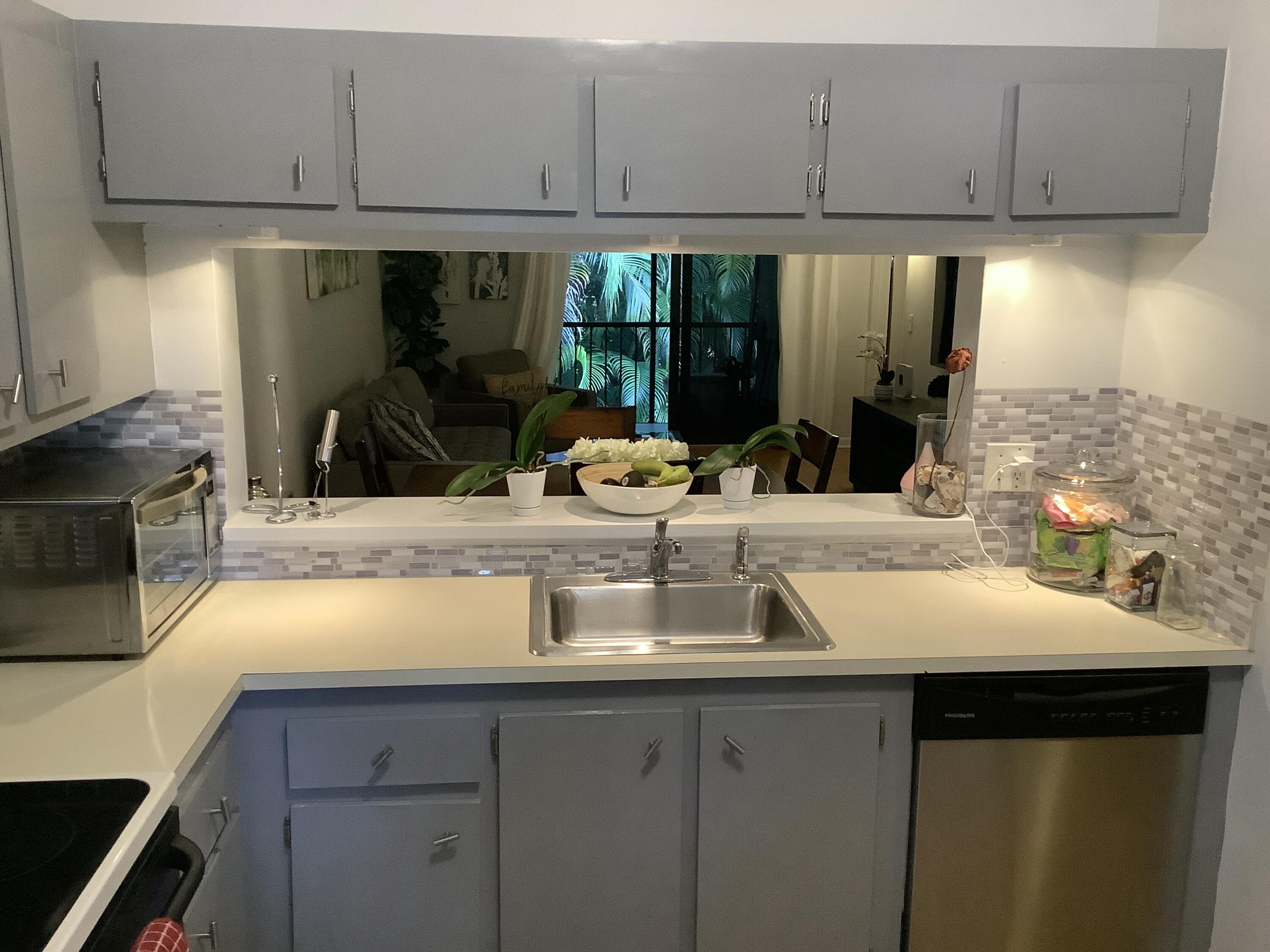 22040 Palms Way, Unit 204 Boca Raton, FL 33433 - Photo 6 of 20 a kitchen with granite countertop a sink and cabinets