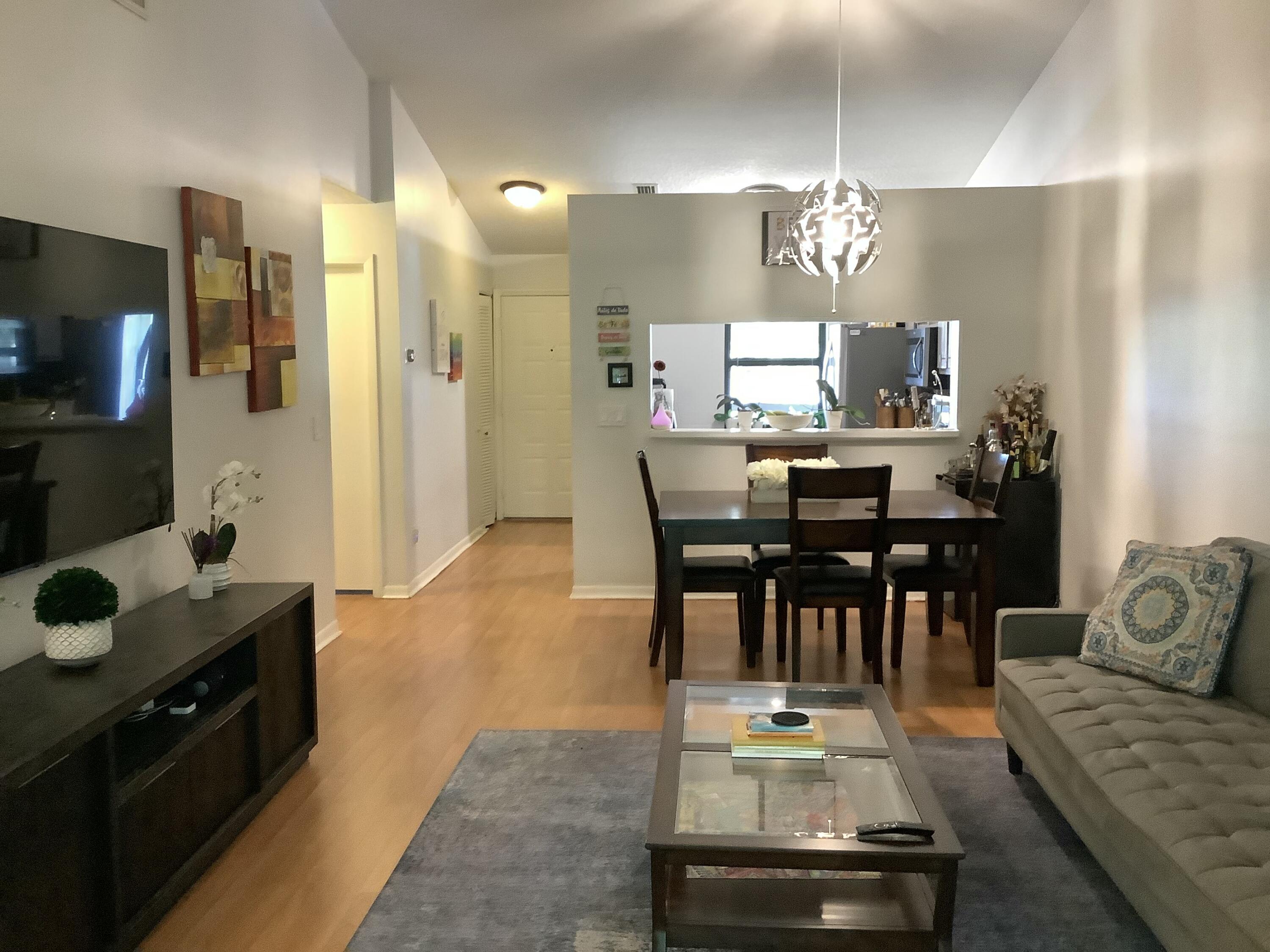 22040 Palms Way, Unit 204 Boca Raton, FL 33433 - Photo 8 of 20 a living room with furniture and a dining table with kitchen view