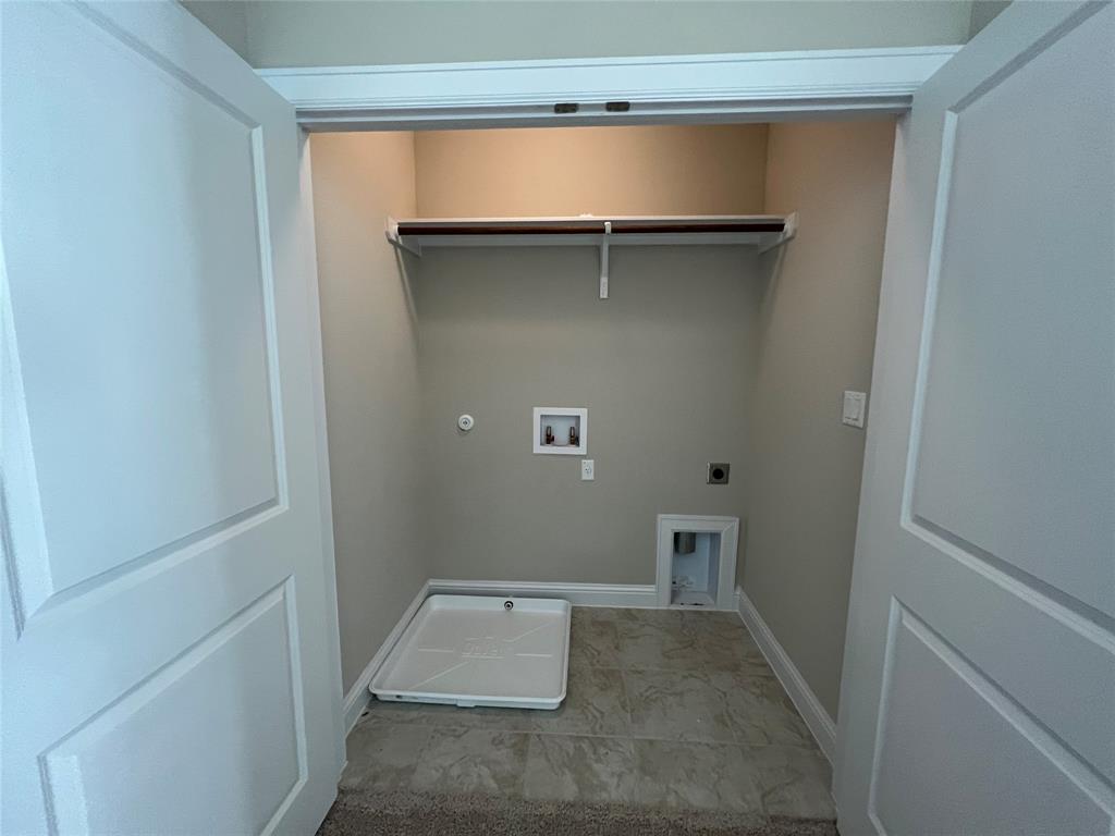 128 Free Stone Drive Georgetown, TX 78628 - Photo 22 of 29 Dedicated laundry area featuring a tile floor, utility hookups, wall shelving, and bi-fold doors