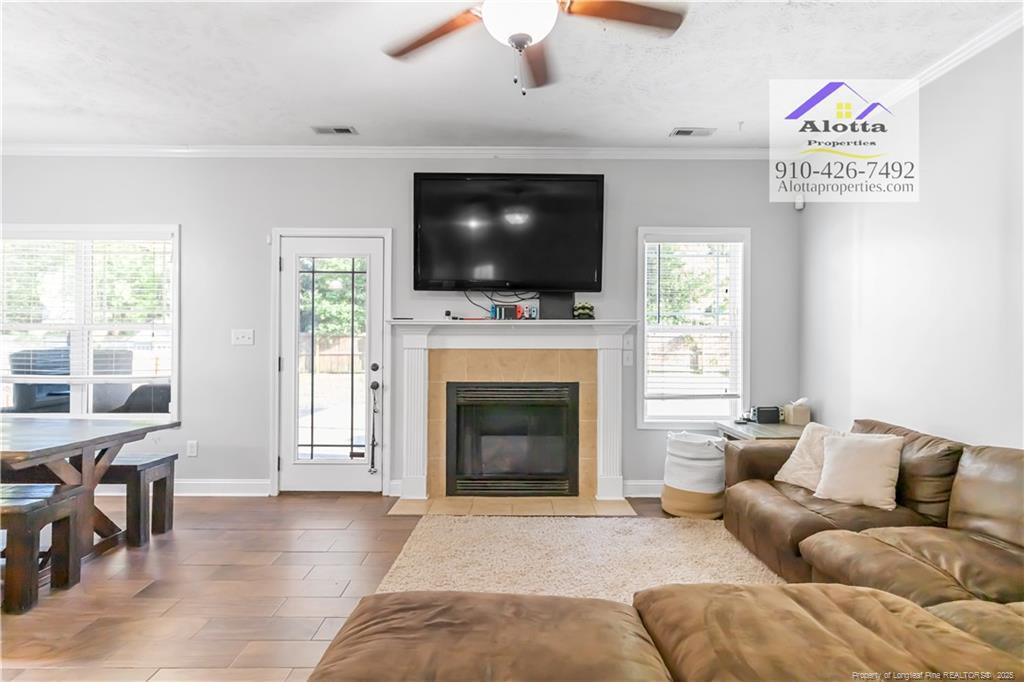 4112 Newgate Street Fayetteville, NC 28306 - Photo 11 of 32 a living room with furniture a flat screen tv and a fireplace