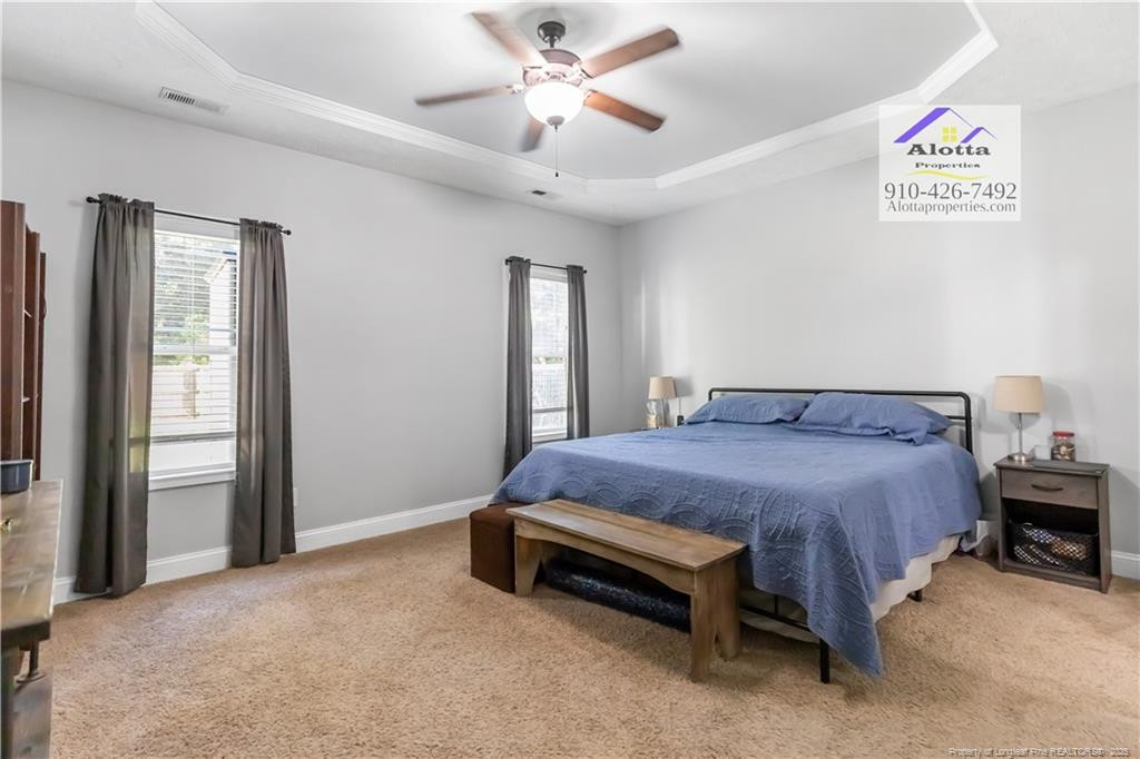 4112 Newgate Street Fayetteville, NC 28306 - Photo 14 of 32 a spacious bedroom with a bed and a chandelier