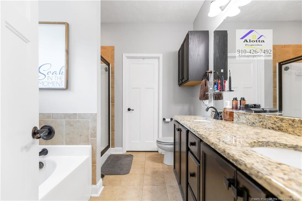 4112 Newgate Street Fayetteville, NC 28306 - Photo 17 of 32 a bathroom with a granite countertop sink and a mirror