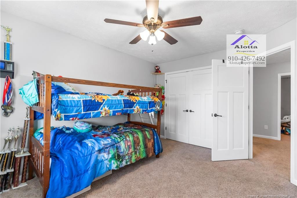 4112 Newgate Street Fayetteville, NC 28306 - Photo 23 of 32 a bedroom with a bed and a chandelier