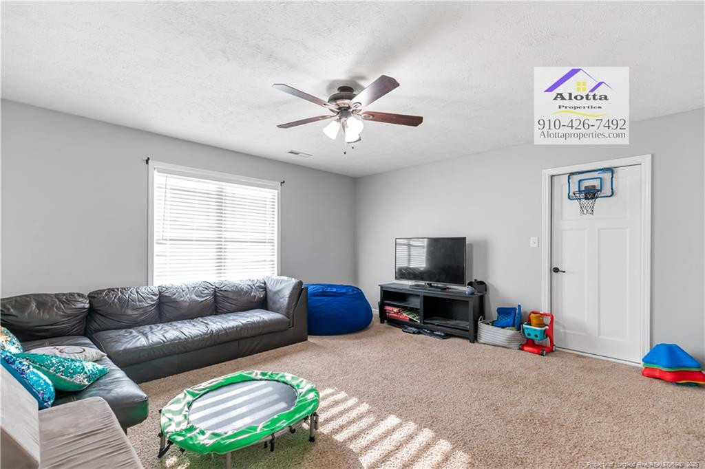 4112 Newgate Street Fayetteville, NC 28306 - Photo 29 of 32 a living room with furniture and a flat screen tv