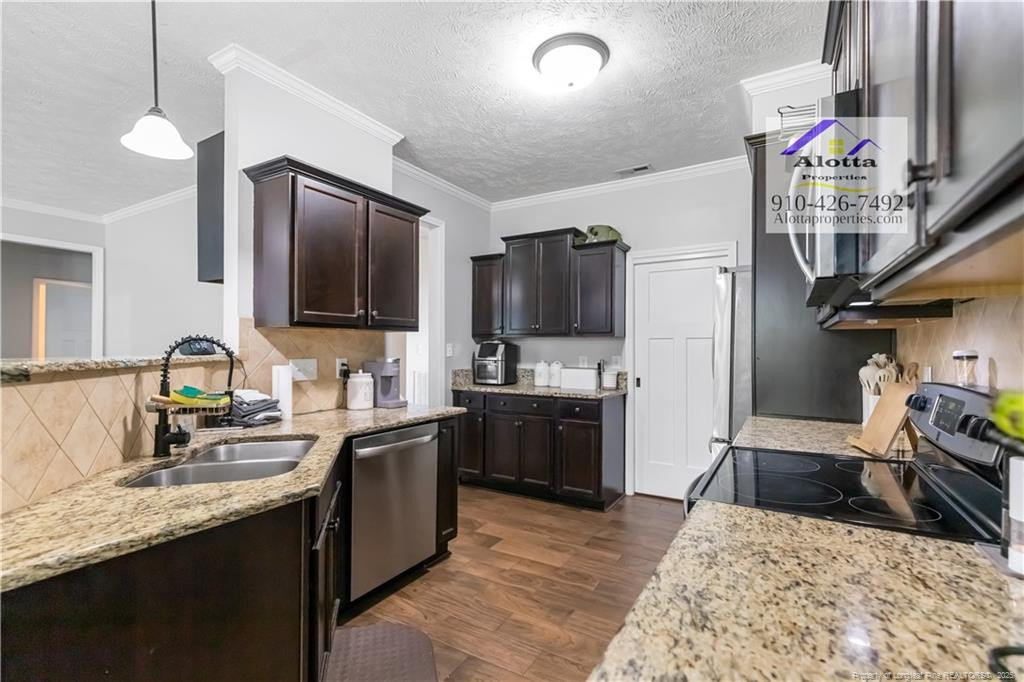 4112 Newgate Street Fayetteville, NC 28306 - Photo 6 of 32 a kitchen with stainless steel appliances granite countertop a sink stove and refrigerator