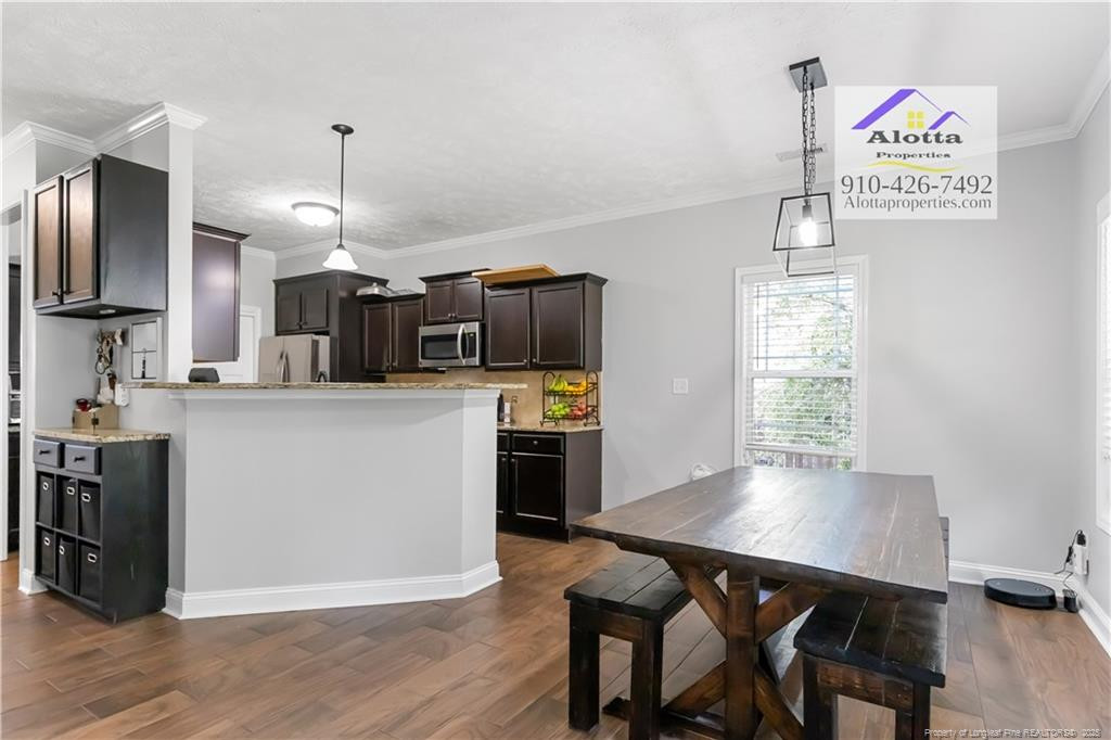 4112 Newgate Street Fayetteville, NC 28306 - Photo 8 of 32 a kitchen with kitchen island white cabinets and stainless steel appliances