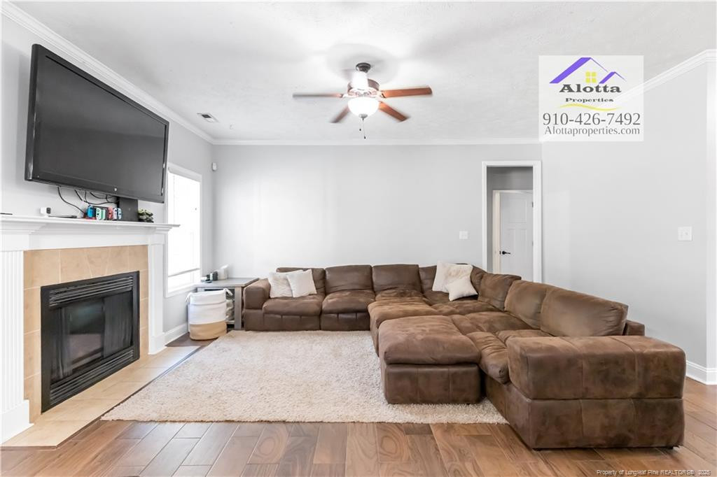 4112 Newgate Street Fayetteville, NC 28306 - Photo 10 of 32 a living room with furniture a flat screen tv and a fireplace